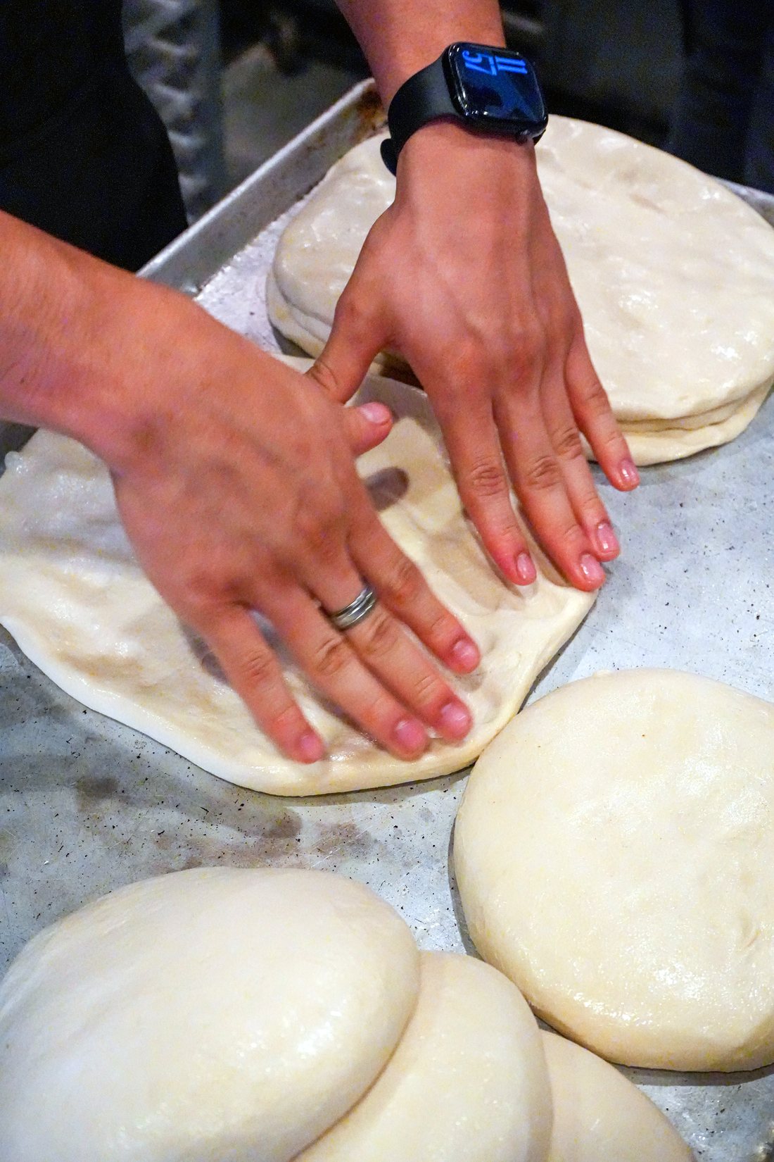 Pizza dough being shaped by hand